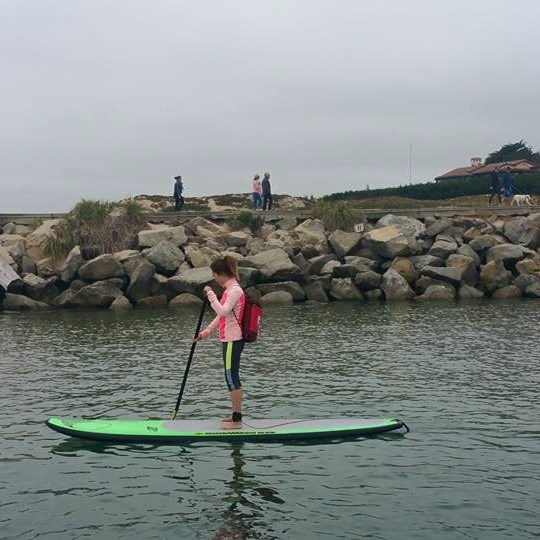 girl on paddleboard in harbor
