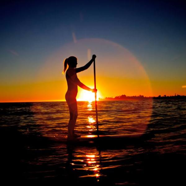 sunset ring around paddle boarder
