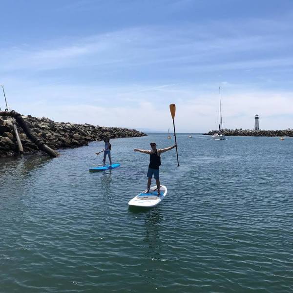 man raising hands on paddleboard