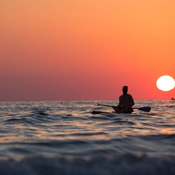 couple floating on paddleboards in the sunset