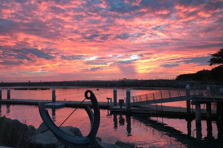 a bench in front of a sunset over a body of water