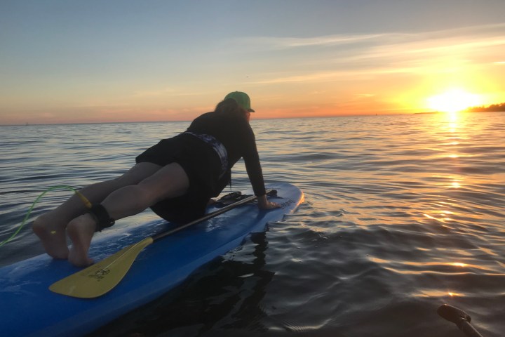 a person sitting on a beach near a body of water
