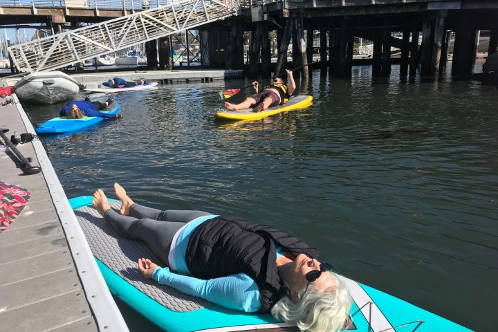 a person sitting on a dock next to a body of water