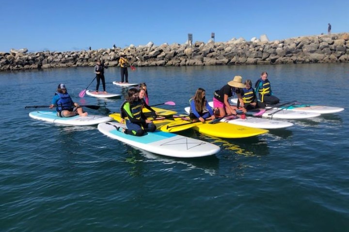 a group of people riding on the back of a boat in the water